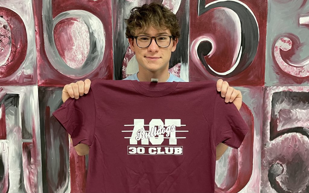 Montgomery Owen holding an ACT 30+ Club shirt