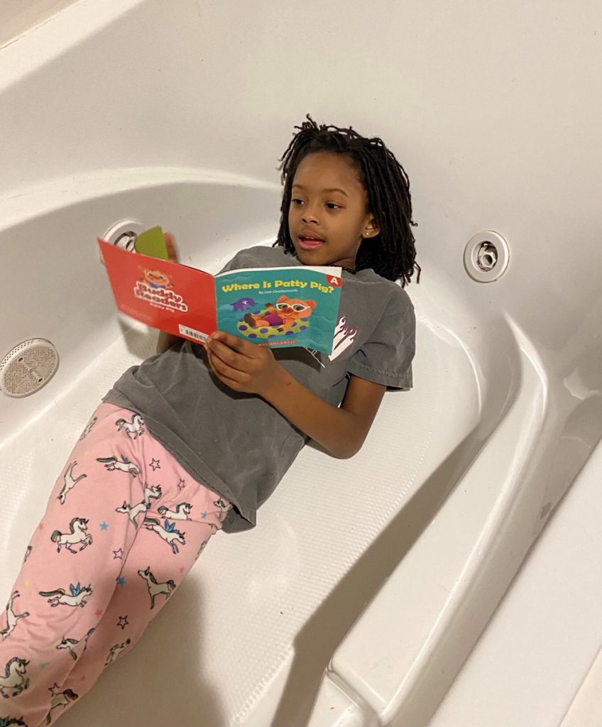 Girl reading to complete reading challenge
