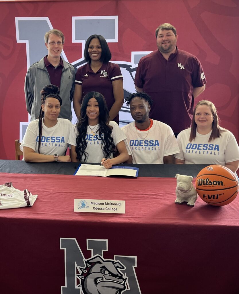 New Albany Bulldog Madison McDonald (center) is surrounded by family and coaches as she signs to play basketball for Odessa College on Friday, February 18. Pictured front row l-r:  Derica Jones, Madison McDonald, Shawn McDonald, Renea McDonaldBack row l-r:  NAHS Assistant Girls Basketball Coach Phillip Laney, NAHS Head Girls Basketball Coach Micha Washington, NAHS Athletic Director Cody Stubblefield